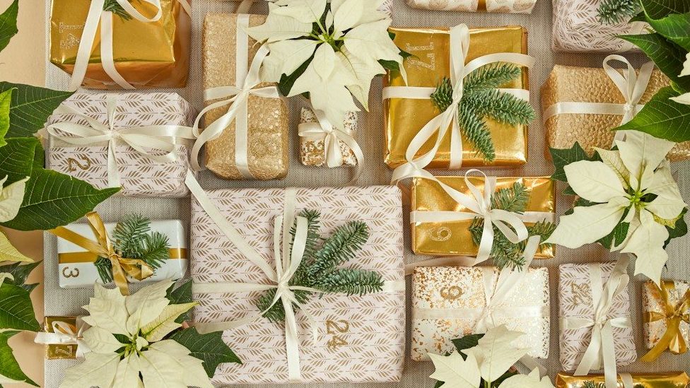 A table topped with lots of white flowers and wrapped presents
